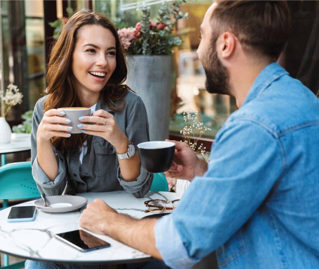 Couple sitting together chatting with coffee at an outdoor cafe